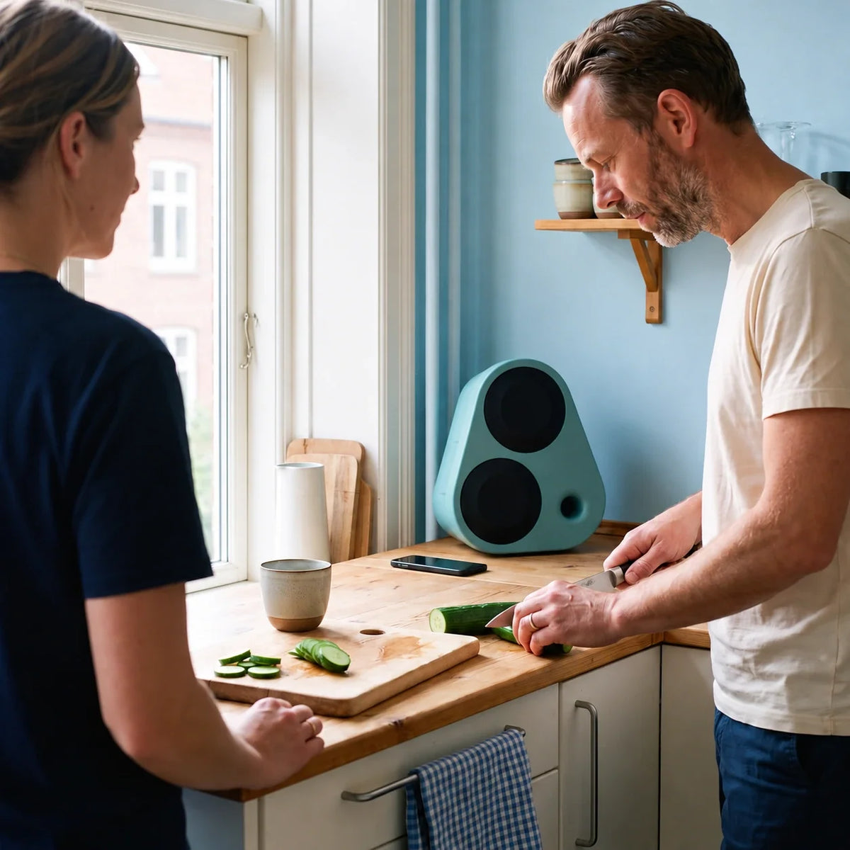 Green Enkl Sound ES2 in a kitchen with light blue walls and two people cooking #color_green